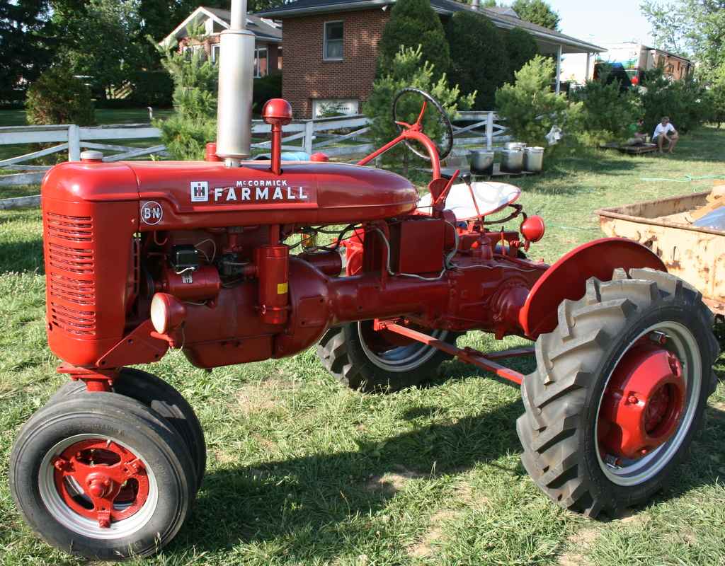 A tractor parked in the grass Description automatically generated