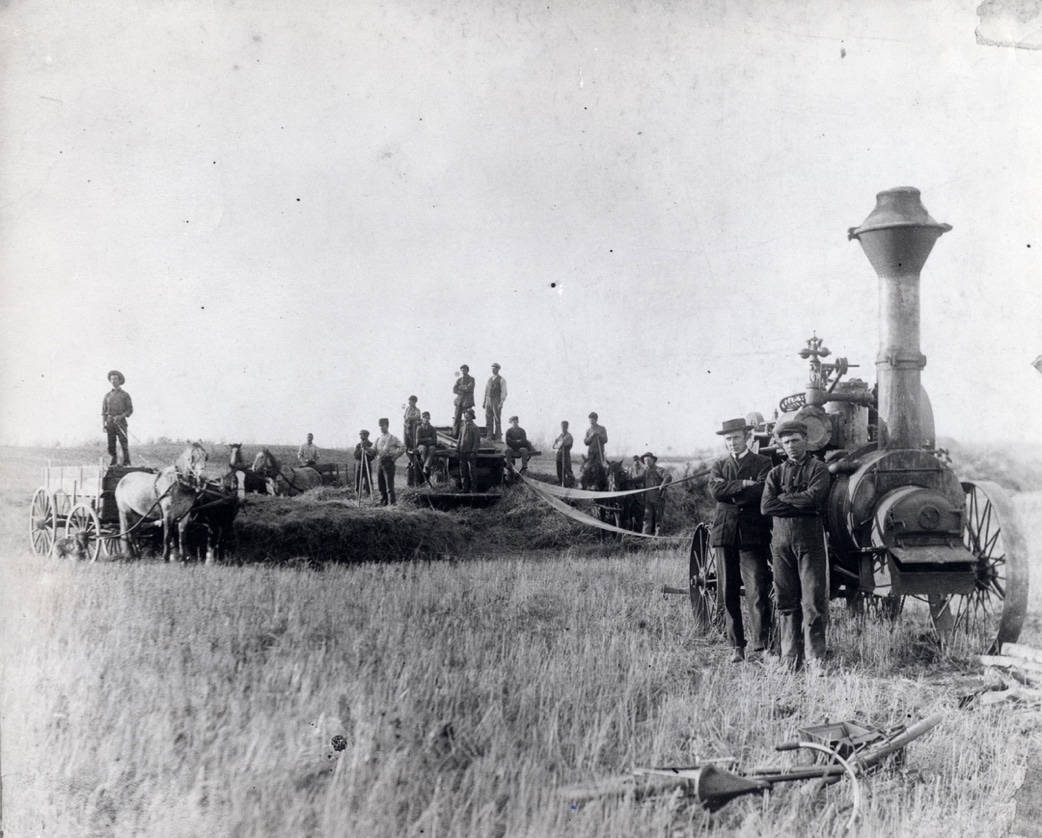 An L.D. Sawyer portable steam engine driving a hand-fed thresher