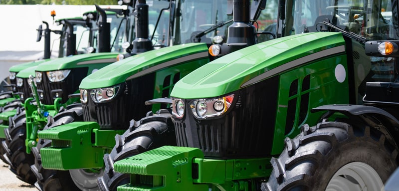 Several green tractors parked in a row