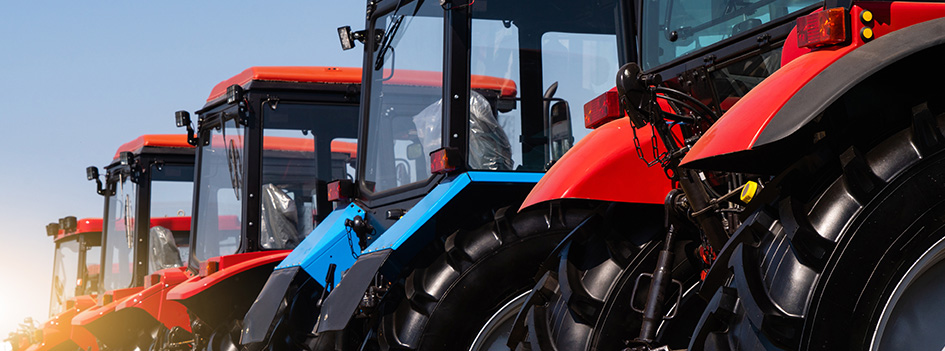 Agricultural tractors sale, blue tractor in between red tractors